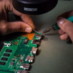 Hands soldering components on circuit board